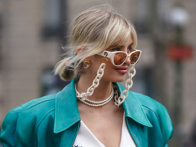 Bloggerin Xenia Adonts mit trägt eine auffällige Sonnenbrille mit Brillenkette. | © Getty Images | Edward Berthelot
