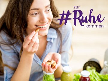 Frau isst Cashewkerne | © iStock.com | RossHelen