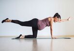 Schwangere Frau macht Fitnessübung Arm-Beinheben | © iStock.com / ArtistGNDphotography