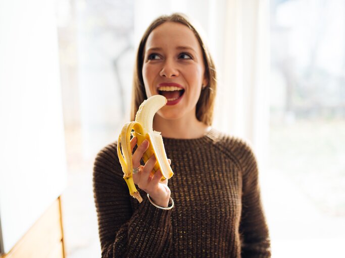 Frau isst eine Banane | © Getty Images/ProfessionalStudioImages