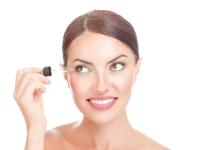 Frau hält Wimpernserum an ihr Auge | © ©:shutterstock/HBRH