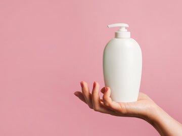 Frau hält Shampoo in der Hand | © AdobeStock/Nastya