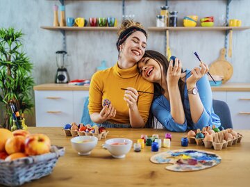 Freundinnen bemalen bunte Ostereier | © GettyImages/LordHenriVoton