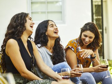 Frauengruppe unterhält sich und lacht gemeinsam | © GettyImages/Morsa Images