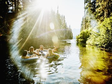 Freundinnen baden zusammen im See und haben Spaß | © GettyImages/	Thomas Barwick