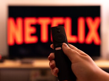 Netflix-Logo auf einem Fernseher mit schwarzem Hintergrund | © GettyImages/NurPhoto