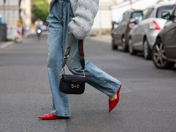 Model Lea Naumann kombiniert rote Ballerinas zu einer weiten Jeans | © GettyImages/	Christian Vierig