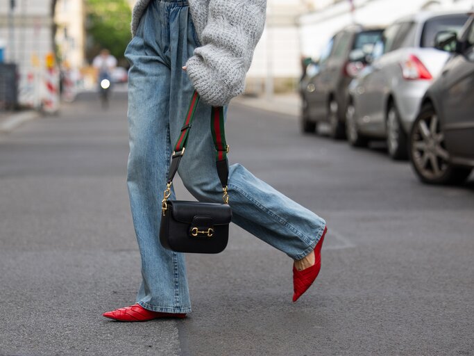 Model Lea Naumann kombiniert rote Ballerinas zu einer weiten Jeans | © GettyImages/	Christian Vierig