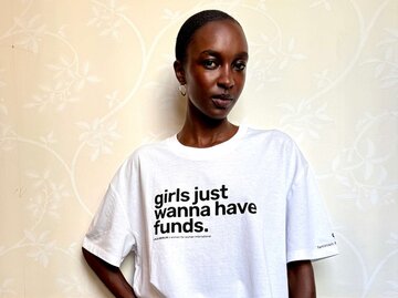 Frau mit weißen Printshirt ("girls just wanna have funds") | © Women for Women International