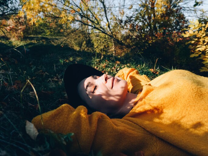 Glückliche Frau liegt in der Herbstsonne | © AdobeStock/	Maryna Terletska