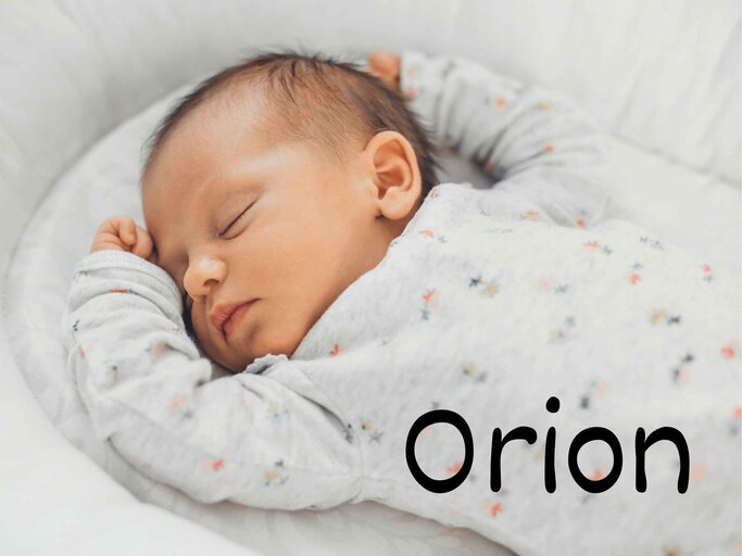 Ein schlafendes Baby liegt entspannt in einem grauen, mit Blumen gemusterten Strampler auf einer weißen Unterlage - rechts unten steht der Jungenname Orion. | © Adobe Stock/Strelciuc