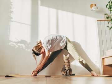 Frau macht Yoga mit ihrer Katze | © GettyImages/	Kseniya Ovchinnikova