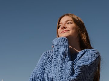 Frau lächelt, blauer Himmel | © 	GettyImages/Yulia Petrova