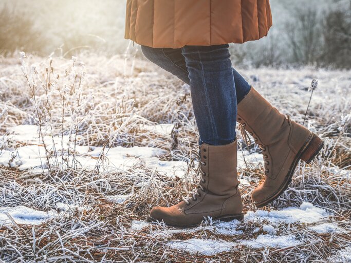 Frau trägt Winterstiefel bei frostigen Temperaturen | © GettyImages/encierro