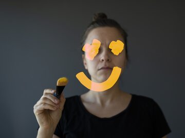 Frau zeichnet lachendes Smiley auf einen Spiegel | © GettyImages/	Alpgiray Kelem